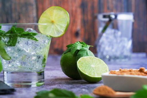 A process of preparing a refreshing drink with lime slices, mint and ice