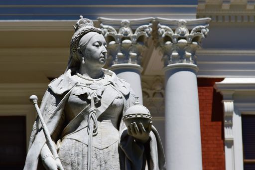 A close shot of Queen Victoria's statue with a blurred background at daytime