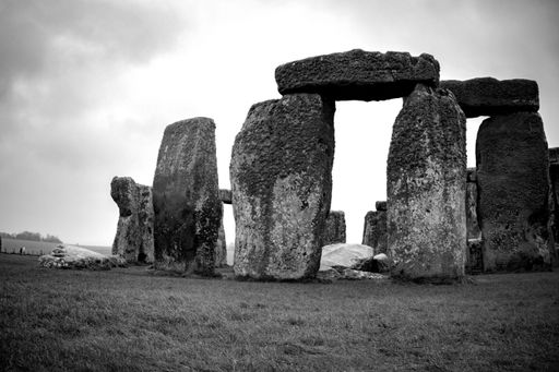 A black and white shot of Stonehenge, showcasing ancient stone structures against a cloudy sky
