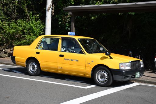 A yellow taxi driving through the streets of Yokohama, Japan