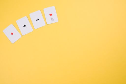 A top view of four aligned card ace  isolated on a yellow background with free space