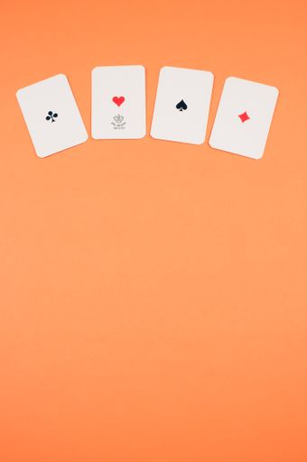 A top view of four aligned card ace  isolated on an orange background with free space