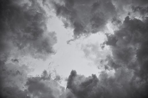 A low angle greyscale of a dark cloudy sky in the evening - perfect for backgrounds and wallpapers
