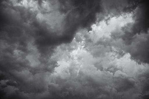 A low angle greyscale of a dark cloudy sky in the evening - perfect for backgrounds and wallpapers