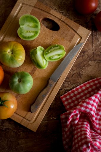 A top view of fresh green tomatoes on a cutting board