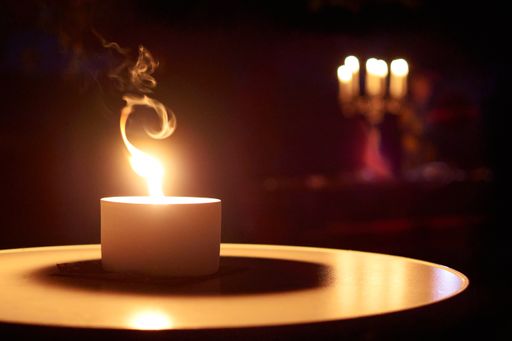A burning candle in a dark room