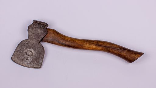 A top view of an old used metal rusty sharp axe on a white surface