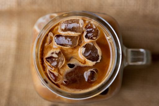 A top view of a cup of cold coffee with ice