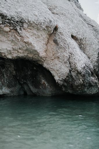 A vertical shot of body of water near a rock formation