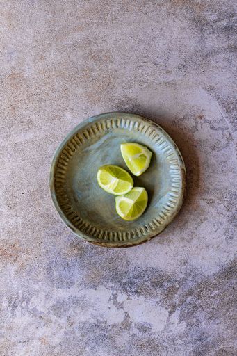 Lime Wedges in ceramic bowl on marble surface