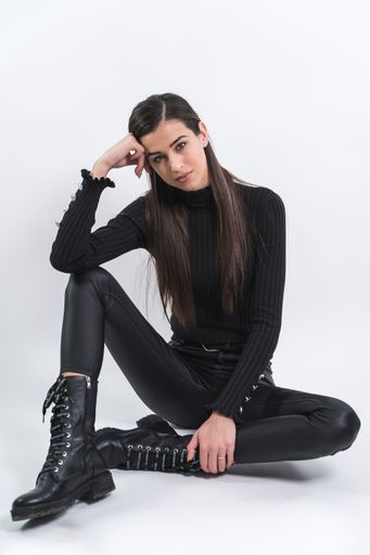 A young stylish Caucasian female posing in a studio