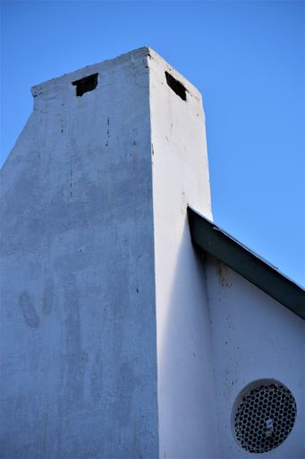 A vertical shot of a stone structure on a blue clear background