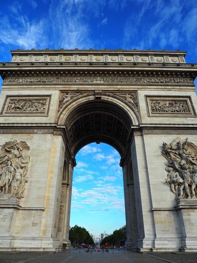 A vertical shot of Arc de Triomphe in Paris, France under the bright skyline