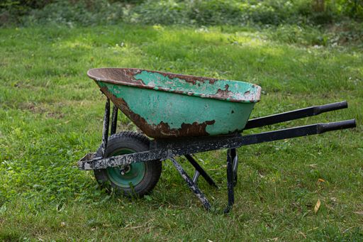An old green wheelbarrow in the garden