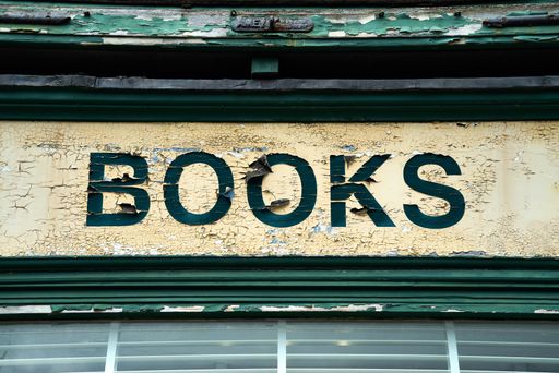 A closeup of a rusted sign that says "books"