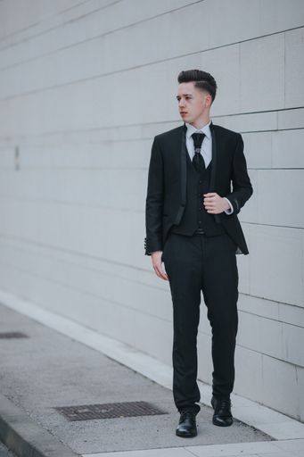 A young attractive Caucasian man with piercings wearing a black suit