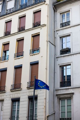 A vertical shot of vintage buildings with a European Union flag in Paris, France