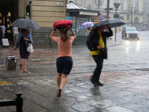 The people run under summer rain, blurred motion effect. Turin, Italy.