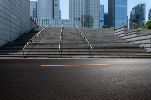 A shot of empty ground in front of a stairway leading to modern office buildings