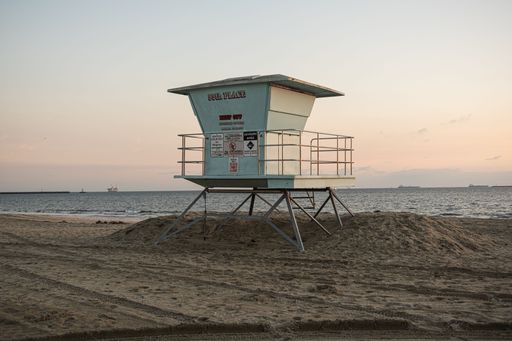 A silhouette of a lifeguard tower against a vibrant sunset in Long beach in January, Los Angeles