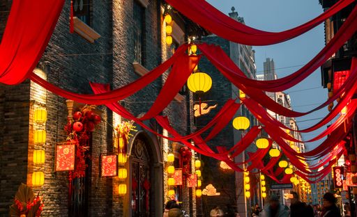 A vibrant Chinese tourist district adorned with lanterns and red silk during Spring Festival