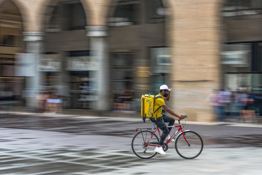 A porter at work quickly crosses the square in Brescia, Italy