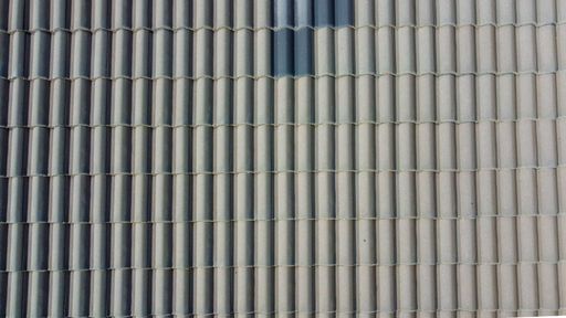 Grey roof tiles arranged in a regular pattern, creating a textured and uniform surface