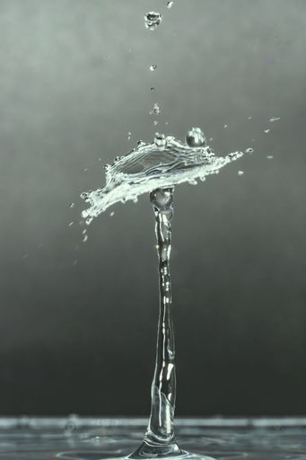 A stunning close-up of a water droplet splash with intricate details on a smooth background.