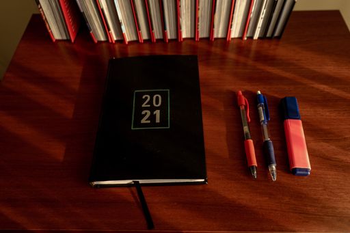 A top view shot of a notebook and some pens on a table