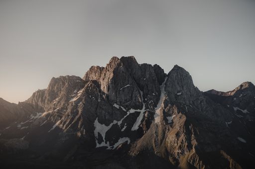 A beautiful view of the mountains covered in snow on a gloomy day