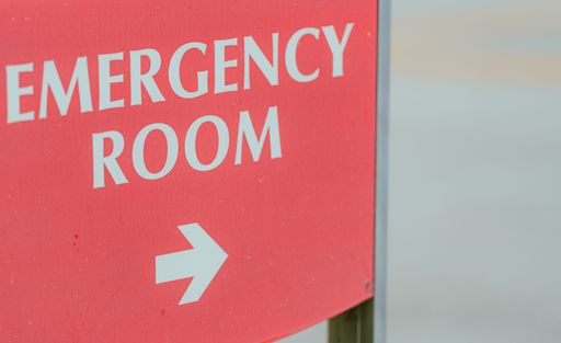 A red EMERGENCY ROOM sign in a hospital