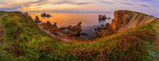 A beautiful view of the colorful clouds during the sunset over the cliff, rocks and the ocean