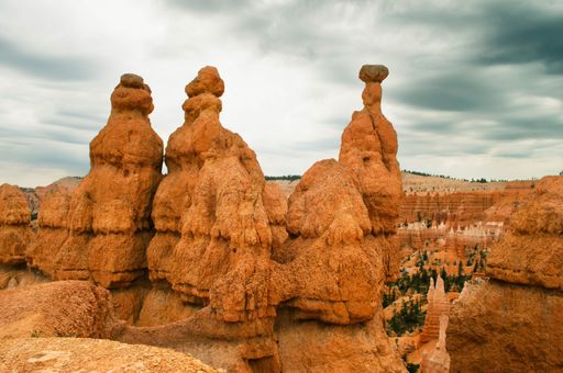 Hoodoos in Bryce Canyon National Park under a cloudy sky, showcasing unique geological formations.