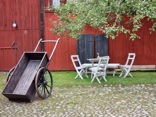 Cozy outdoor furniture and vintage cart in the yard, Orebro, Sweden
