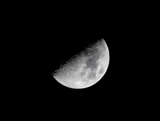 A detailed image of the moon's surface with craters visible against a dark night sky.