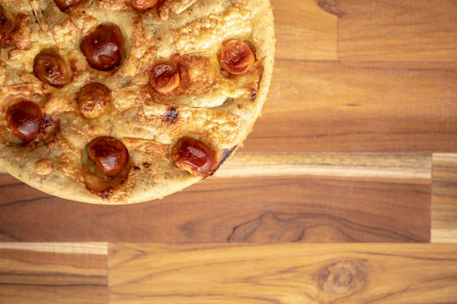 A pizza on a wooden table viewed from above