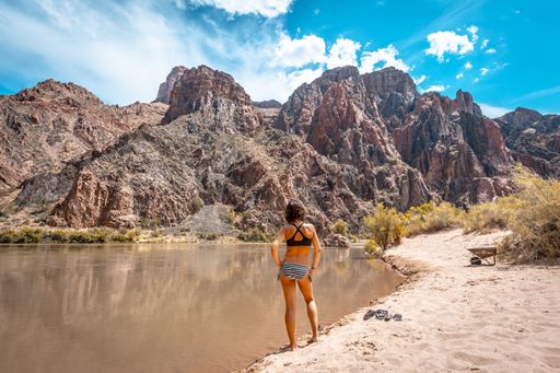 A beautiful shot of a woman in a swimsuit standing near Colorado River at the Grand Canyon