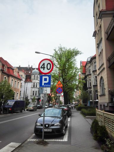 A street with a speed limit of 40 kilometers per hour near the parked cars in the city center