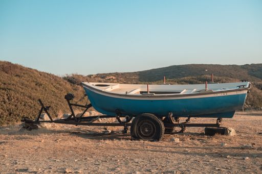 A blue boat on a barrow in the seashore