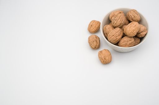 White bowl with Stack Walnuts isolated on a white background with free space