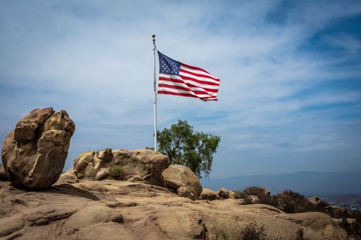 the united states of america flag flutter on rock against cloudy sky