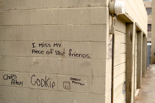 Many different writings on a white street wall