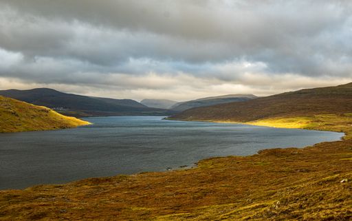 A beautiful scenery of rocky cliffs by the sea in the Faroe Islands under a cloudy sky