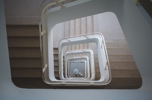 A high angle shot of a square spiral staircase on a building