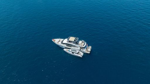 Aerial view of a luxury yacht and boat floating on the clear blue ocean, capturing the essence of marine leisure and travel.