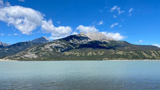 A breathtaking view of a glacial-fed lake in the Canadian Rockies, surrounded by rugged mountain peaks
