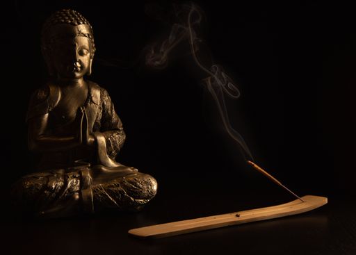 A closeup shot of a Buddha statue on a black background