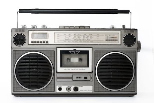 Vintage boombox radio cassette player with speakers and handle isolated on white background.