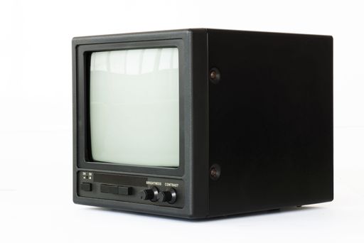 Vintage black CRT monitor with brightness and contrast knobs isolated on white background.