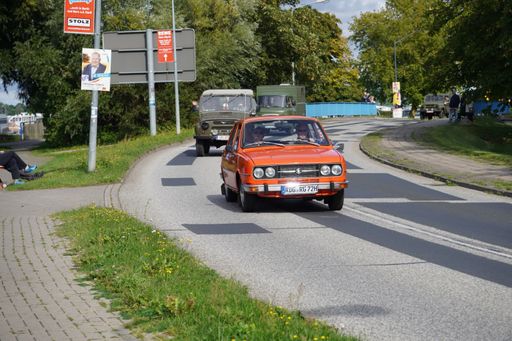 A row of vintage retro automobiles and trucks driving on a road in Ribnitz Damgarten, Germany